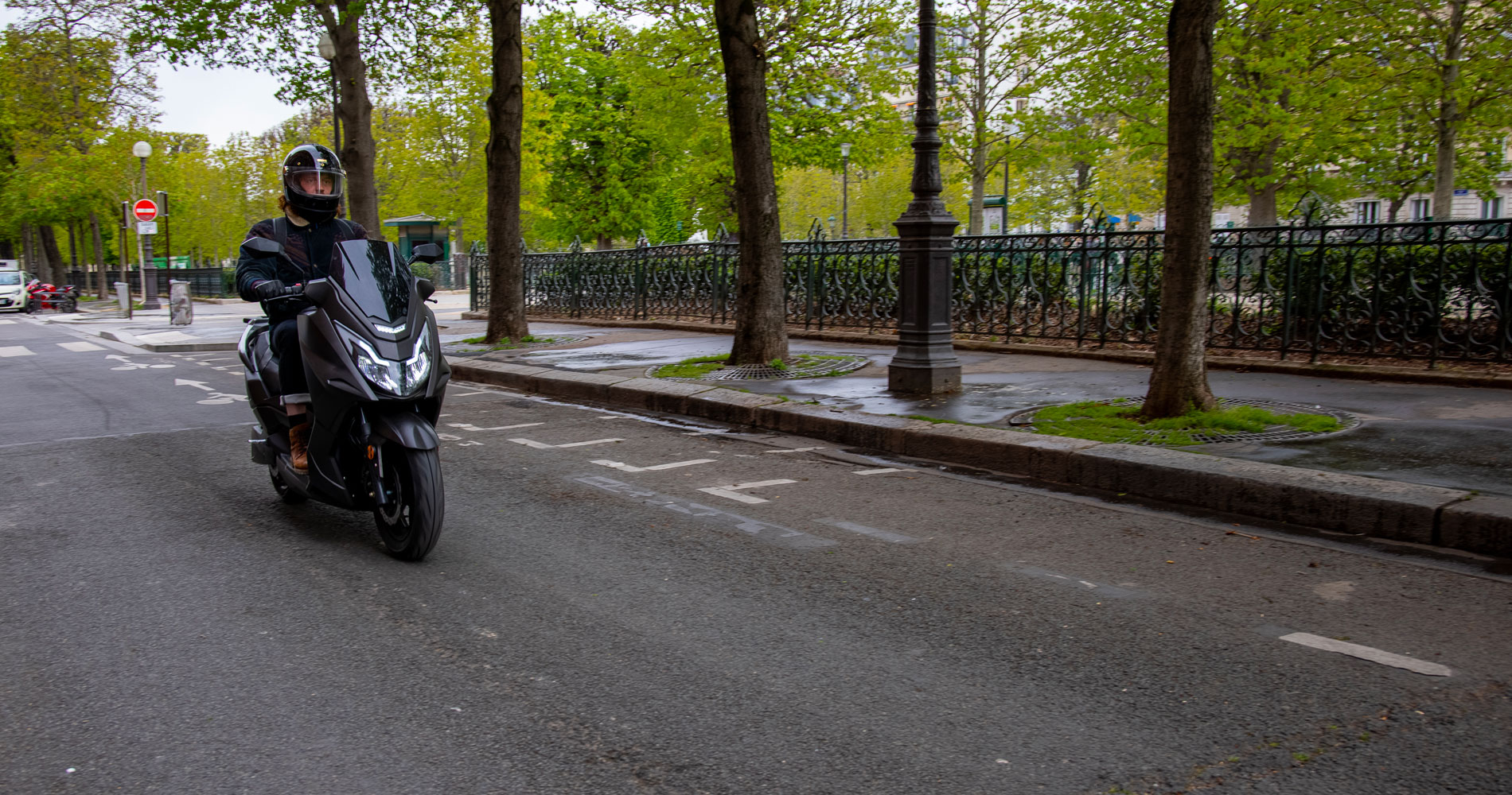 Jeune homme au guidon du maxi scooter électrique Frison T10