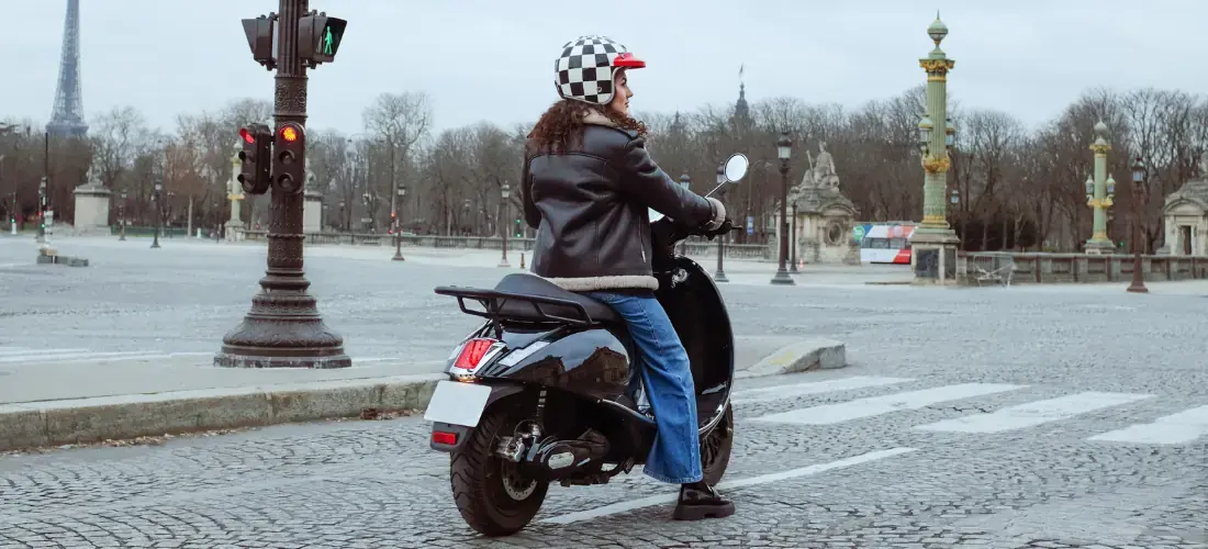 Une jeune femme sur un scooter électrique dans les rues de Paris