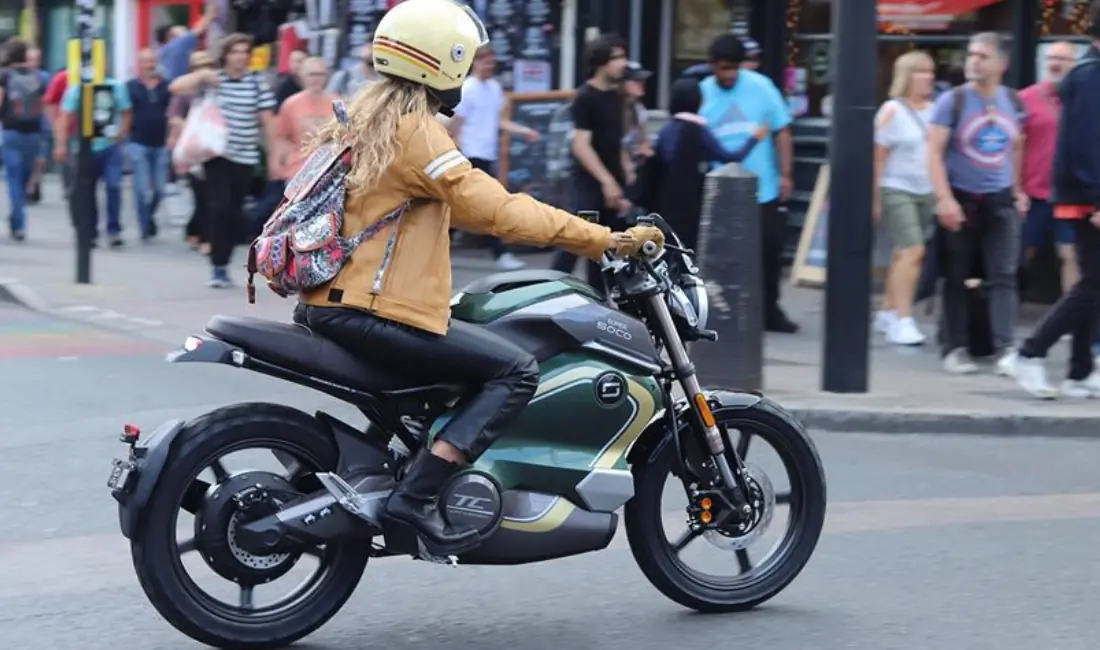 Jeune femme au guidon de la VMoto Super Soco TC Wanderer en ville