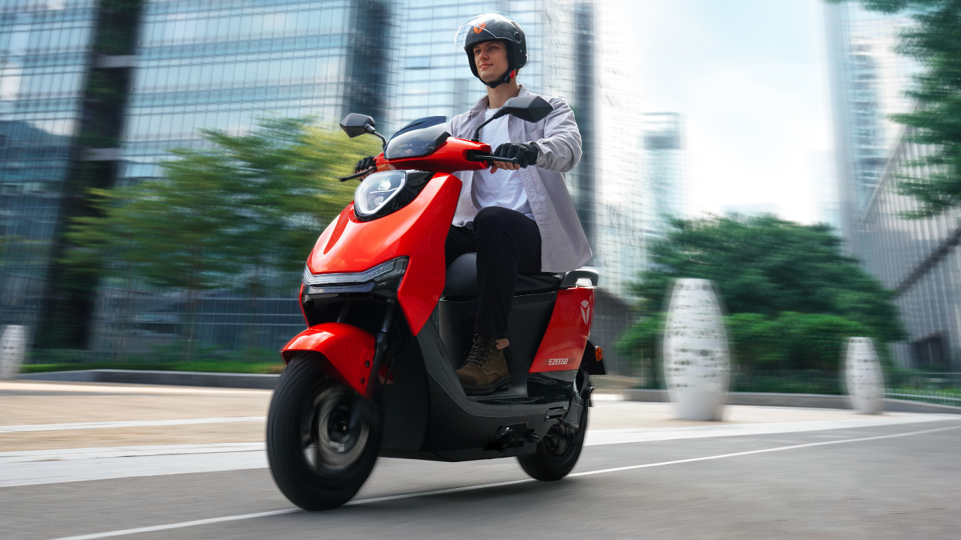 Scooter électrique sans permis Yadea Ezeego rouge conduit en ville par un jeune homme