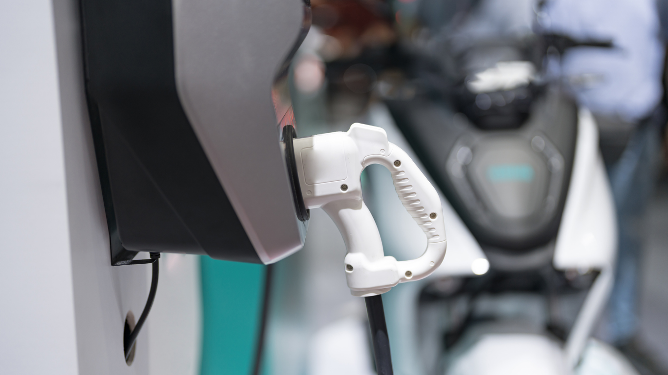 Born de recharge publique avec un deux-roues électrique en arrière-plan